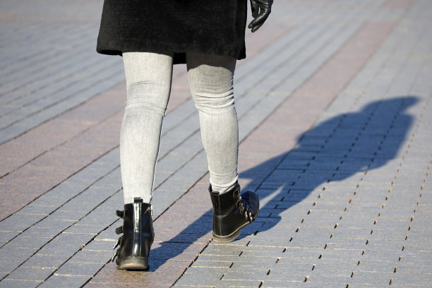 女性腿穿黑色靴子和牛仔裤图片下载