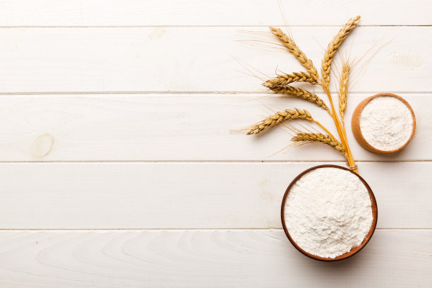 将小麦粉平铺在木碗中，用彩色的背景点缀小麦粉。世界小麦危机图片下载