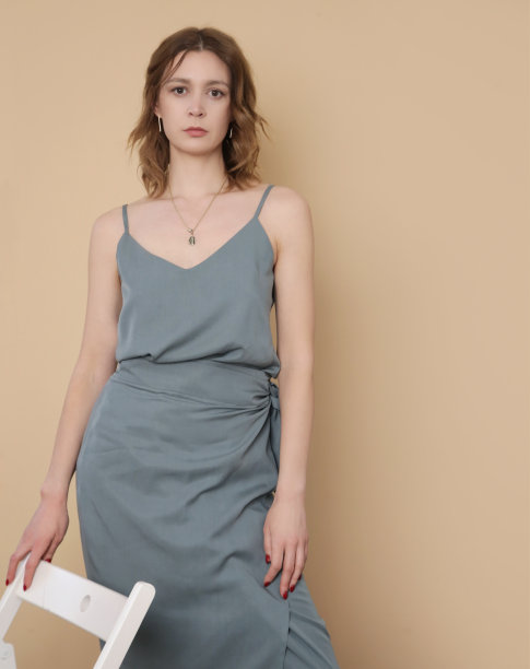 女模特穿蓝灰色背心丝绸上衣和包裹中长裙。时髦的单色夏装。时尚工作室拍摄。图片下载