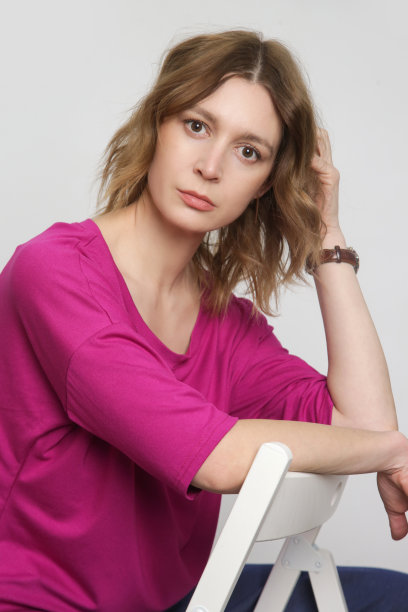 系列工作室照片的年轻女模特穿亮粉色棉蝙蝠翼衬衫图片下载