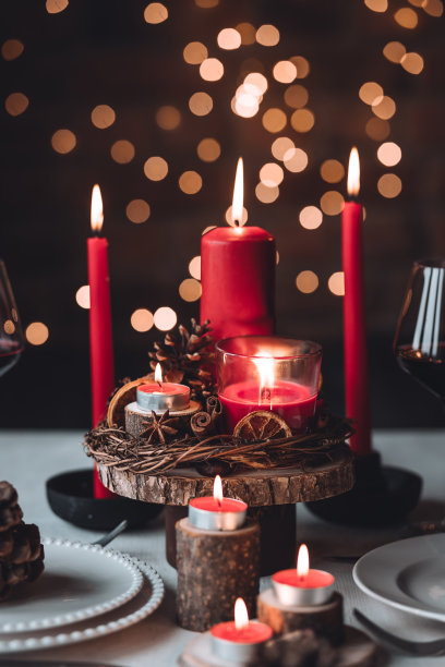 圣诞或新年家庭晚餐的乡村餐桌装饰。配红蜡烛，干橙，圆锥形，肉桂，八角。零废物环保家居。舒适的氛围，深色的背景。近距离图片下载