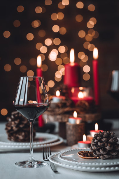 圣诞或新年家庭晚餐的乡村餐桌装饰。配红蜡烛，干橙，圆锥形，肉桂，八角。零废物环保家居。舒适的氛围，深色的背景。近距离图片下载