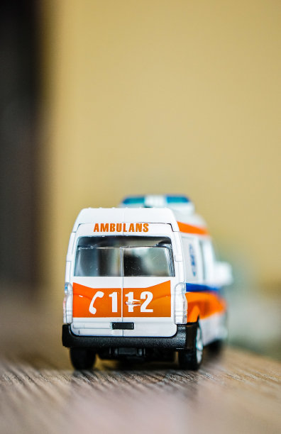 木制表面上的玩具救护车的垂直选择性聚焦特写图片下载