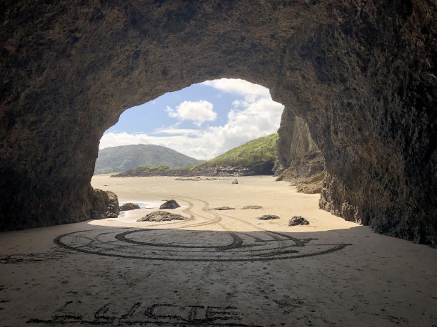 海滩背景下洞穴入口的美丽照片。图片下载