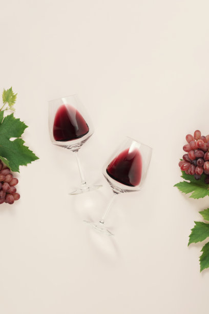 红葡萄酒在粉色背景的玻璃杯中平铺图片下载