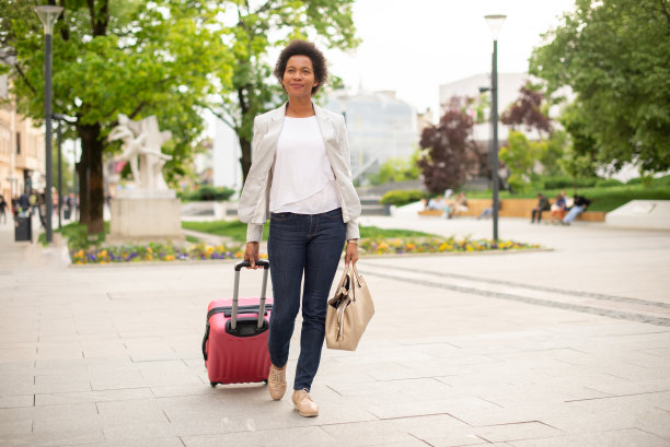 中年妇女带着行李箱走在街上图片下载