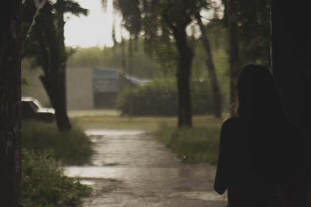 一个年轻女子的剪影背景上的绿色景观图片下载