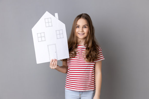 小女孩抱着纸房子，微笑友好，广告中介服务，购房。图片下载