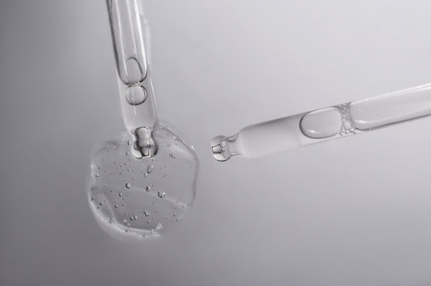 两个移液管放在有液体的浅色背景上。图片下载