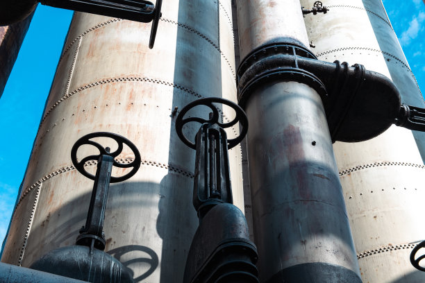 老旧生锈的工业烟囱建筑的低角度视图图片下载