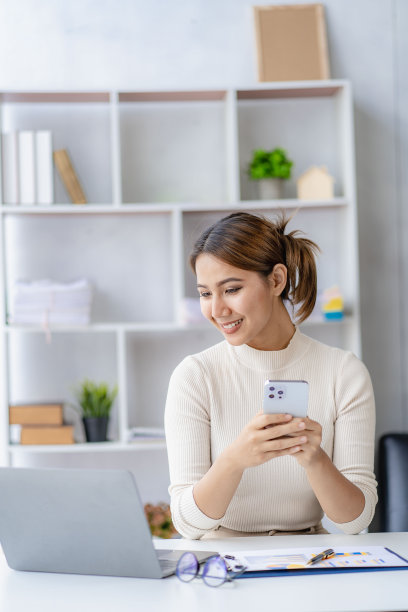 亚洲妇女在智能手机上说话，在家工作，数字电话技术生活方式在家工作与笔记本电脑财务概念图片下载