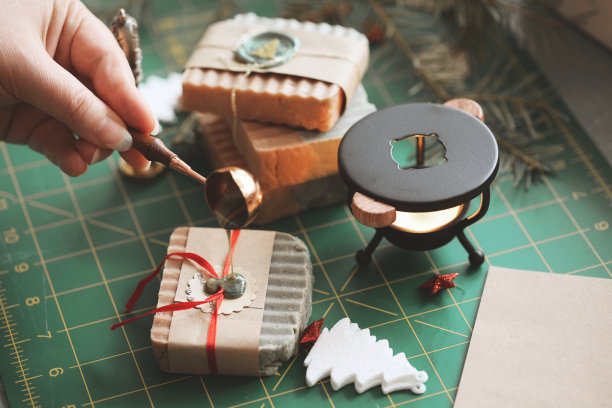 妇女倒热蜡在环保纸包装自制肥皂圣诞礼物包装图片下载