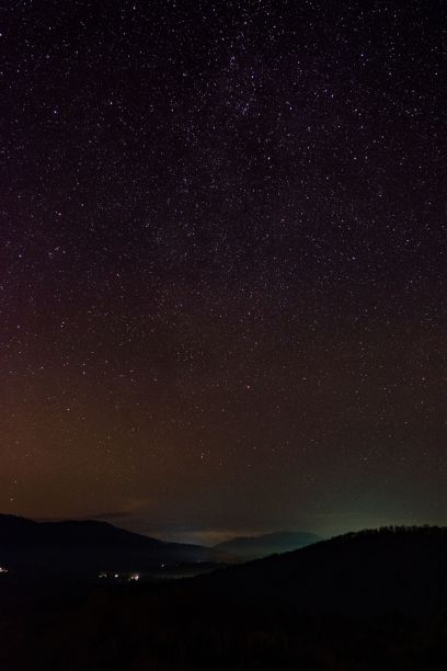 垂直的黑色照片，夜晚美丽的紫色天空和地平线上山脉的轮廓图片下载