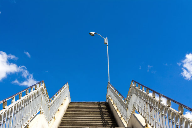 生锈栏杆的旧楼梯通向美丽的蓝天图片下载