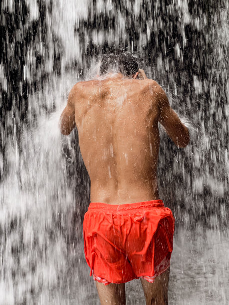 站在瀑布下的人图片下载