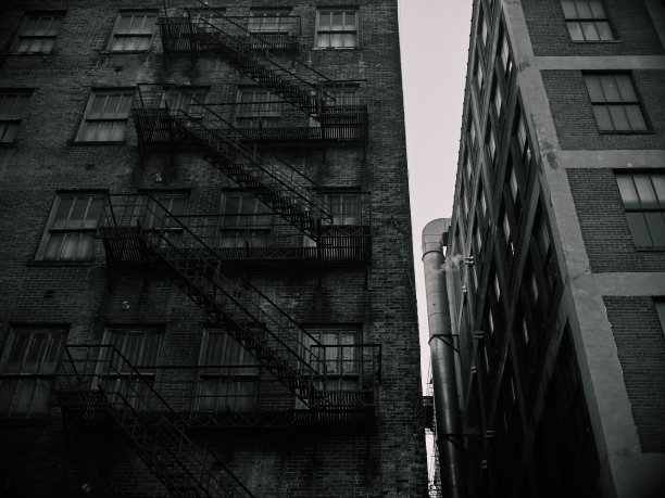 两个带楼梯的公寓建筑的低角度灰度照片——非常适合作为背景图片下载