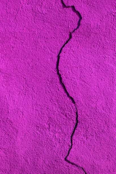 垂直照片的粉红色油漆墙，从上到下有一个大裂缝图片下载