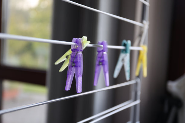 挂在洗衣架上的多个洗衣针的特写肖像。夹子或笔用来把湿衣服挂在室外或室内洗完后晾干的绳子或架子上。图片下载