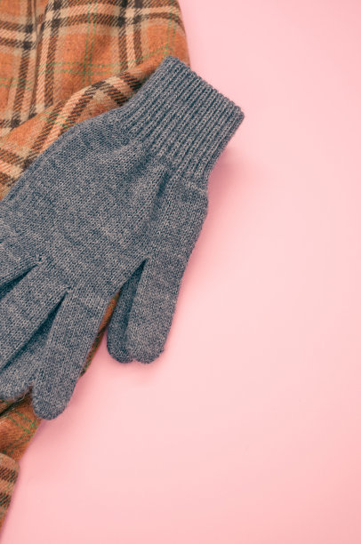特写镜头的围巾针织冬季手套在一个粉红色的表面复制空间图片下载