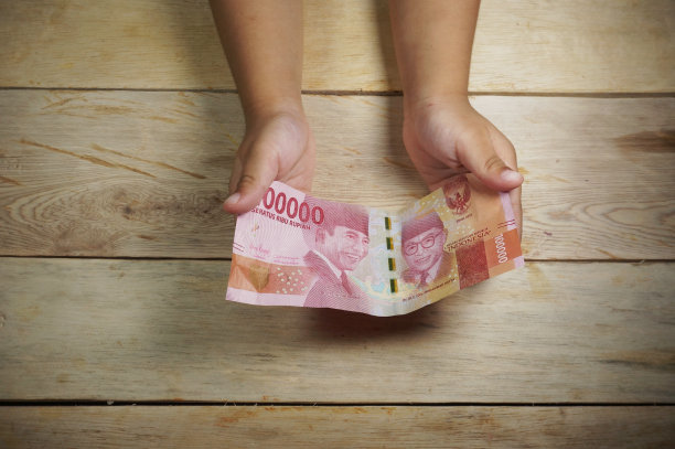 手里拿着印尼货币的小孩。卢比/印尼盾的钱。图片下载