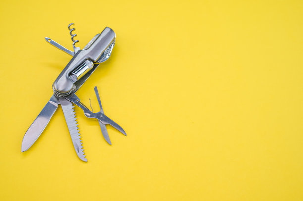 黄色表面上的瑞士军刀的高角度镜头图片下载