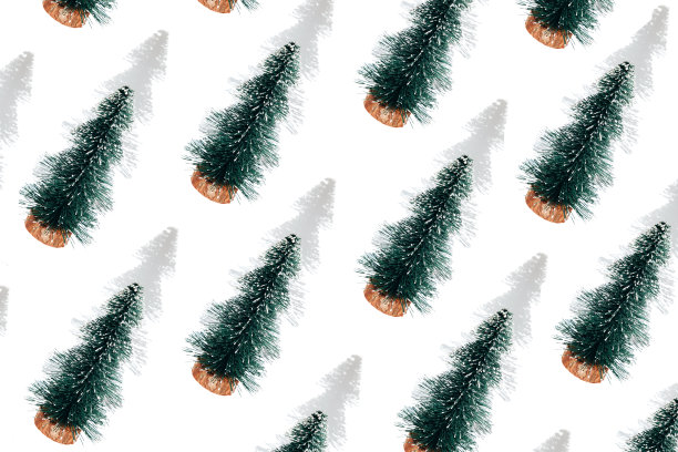 背景与白色背景上的阴影小绿色装饰圣诞树。圣诞节的模式图片下载