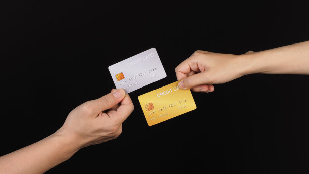 两只手拿着白色背景的金银信用卡。图片下载