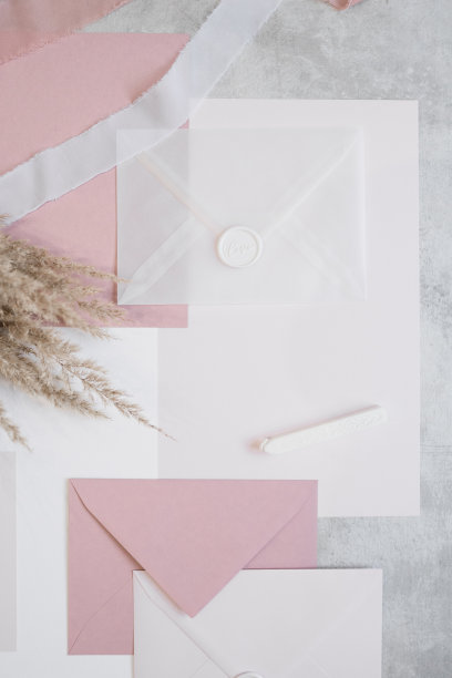 俯视图组成的彩色纸床单，丝带，白色和粉色信封，花束干潘帕斯草。图片下载