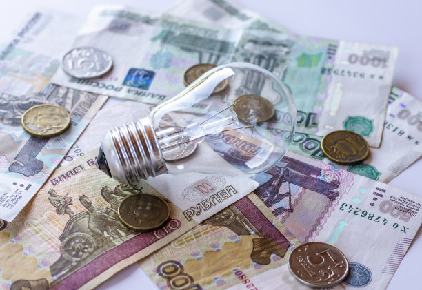 白炽灯和白色背景上的俄罗斯货币。节能理念，用电付费图片下载