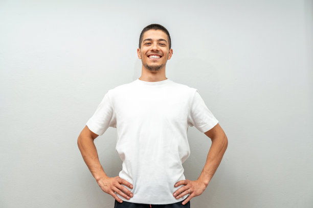 年轻男子的肖像在灰色的墙前图片下载