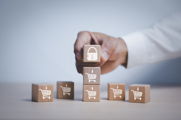 手持立方体木材键块步上表与图标购物车在白色背景，产品降价，网上购物概念，项目管理，公司战略发展。图片下载