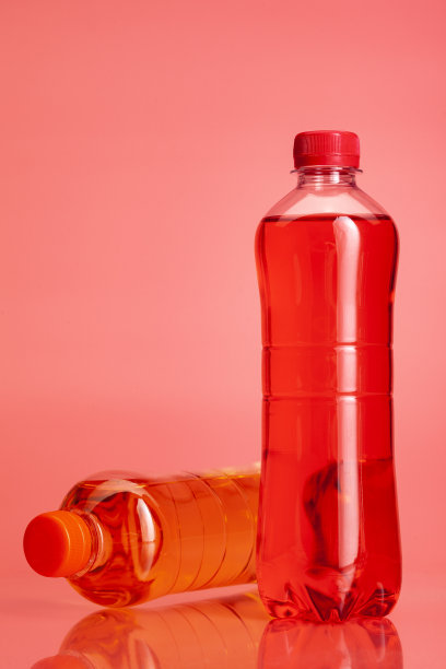 一瓶彩色饮料或柠檬水在明亮的粉红色背景上特写图片下载