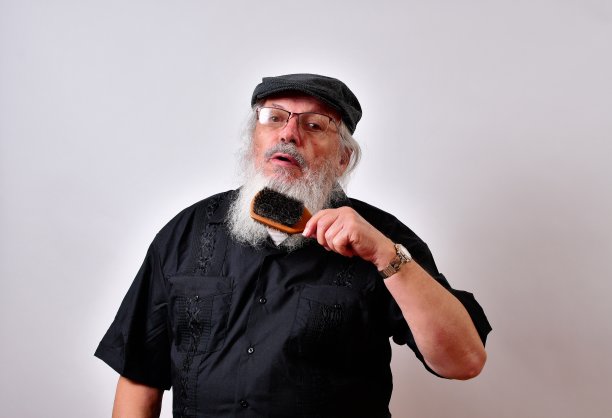 戴着暖气的人用梳子梳理他的熊图片下载