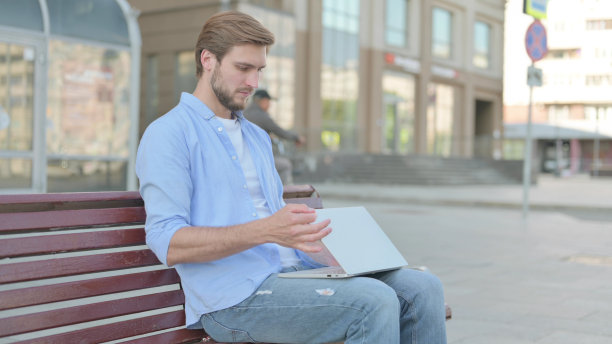 男子关闭笔记本电脑后离开长凳图片下载