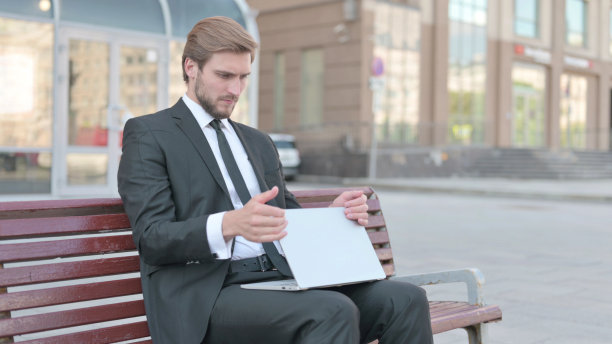 商人关闭笔记本电脑离开长凳图片下载