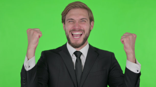 成功的年轻商人在绿色背景下庆祝图片下载