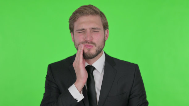 在绿色背景上牙痛的年轻商人图片下载