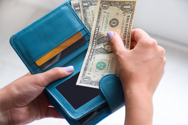 女性手里拿着装有美国现金的钱包图片下载