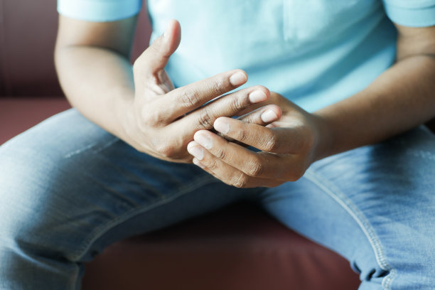 男人坐在沙发上，手疼得厉害图片下载