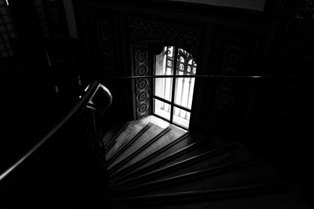 窗户附近楼梯的灰度照片图片下载