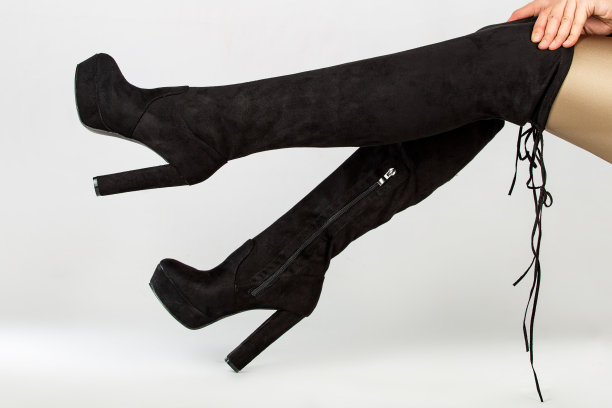 女模特穿着优雅的高跟鞋冬季靴在工作室在白色的背景图片下载