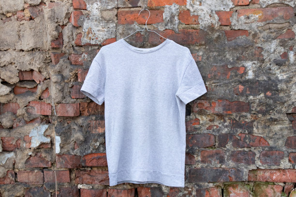 轻薄的羊毛衫挂在衣架上，挂在街上的砖墙上，女装图片下载