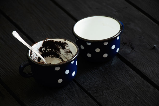 两个杯子，一个有咖啡渣，另一个空的，干净的，黑色木制背景，两个杯子图片下载