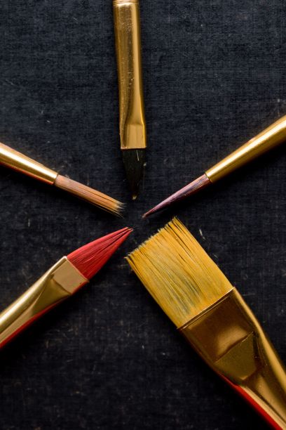 黑色背景与不同大小的金色画笔-概念的艺术用品和绘画图片下载