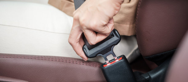 女司机坐在车内在路上驾驶时手系安全带。安全、出行、旅程和运输理念图片下载