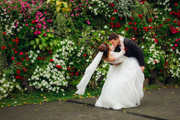 新婚夫妇在野外跳舞，背景是玫瑰色的花园图片下载