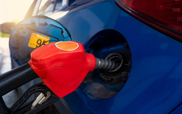 汽车在加油站加油。用汽油加满汽油。加油站汽车油箱的油泵充油嘴。石油工业和服务业。汽油价格与石油危机的概念。图片下载