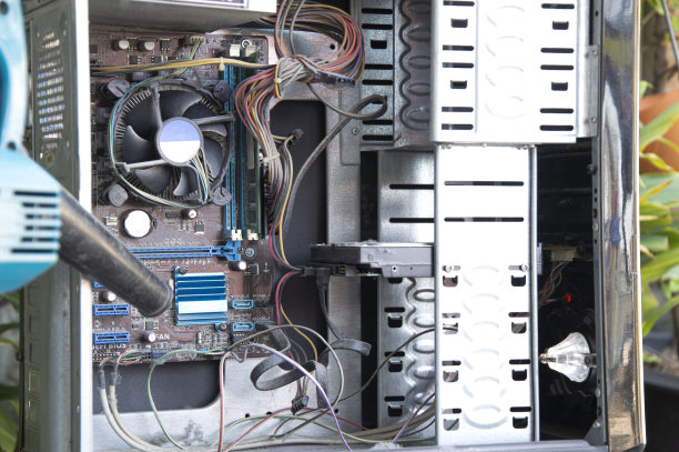 用鼓风机清理积满灰尘的电脑。图片下载