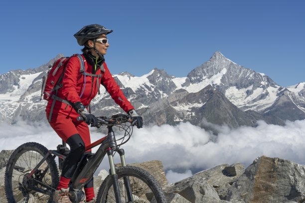 在瑞士阿尔卑斯山骑电动山地车的老年妇女图片下载