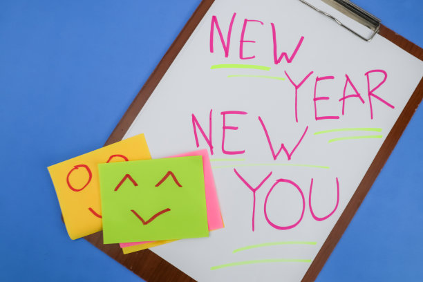 新年新你，用红墨水手写在白纸上，蓝色底色配上欢呼的笑脸。图片下载